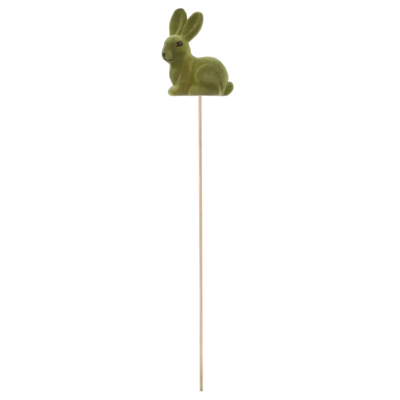 Widok z profilu na zielonego flokowanego zająca na długim drewnianym patyczku o łącznej długości 50 cm. Figurka ma 10 cm wysokości.