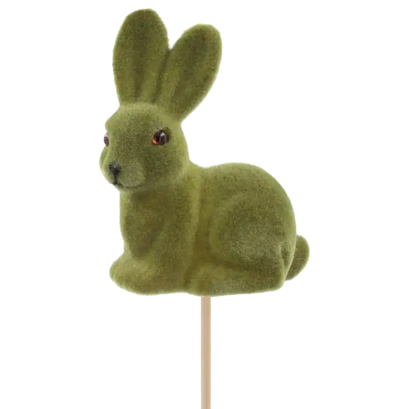 Zbliżenie na zielonego flokowanego zająca na piku o wysokości całkowitej 50 cm. Miękka powierzchnia figurki o wymiarach 10 cm wysokości idealnie dopełni wiosenne stroiki.