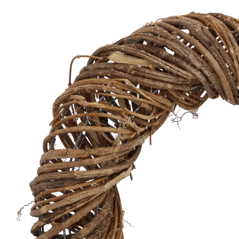 Zbliżenie na fragment wianka z winorośli, ukazujące sposób zaplecenia naturalnych gałązek wokół metalowego stelaża.