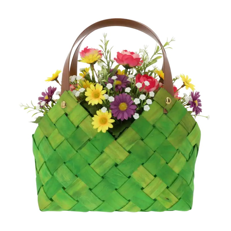 Zielona pleciona torba wypełniona bukietem kwiatów, wyeksponowana na jednolitym tle. Widoczna faktura naturalnego materiału i eleganckie brązowe uchwyty.