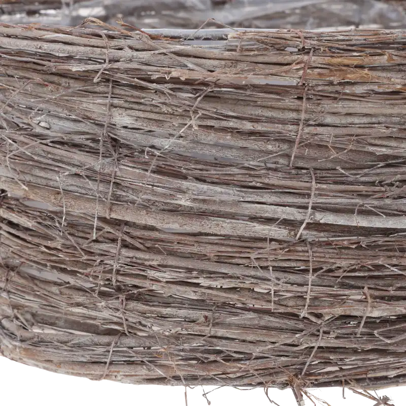 Zbliżenie na fakturę naturalnych patyków, z których wykonano osłonkę. Widoczne sploty tworzące organiczny charakter dekoracji.