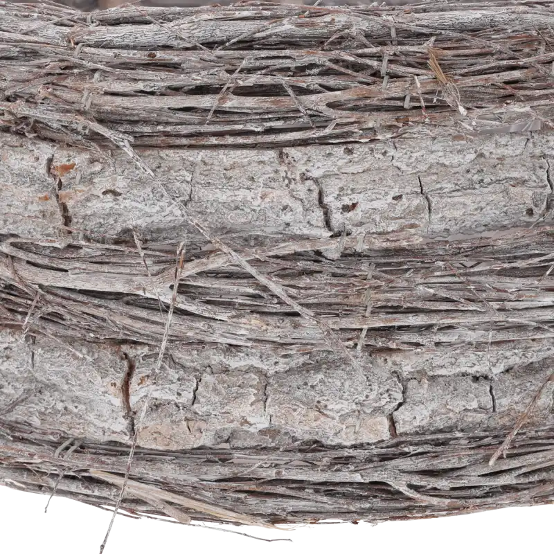 Zbliżenie na strukturę materiału, z którego wykonano osłonkę: naturalna kora drzewna i ozdobne splecione patyki.