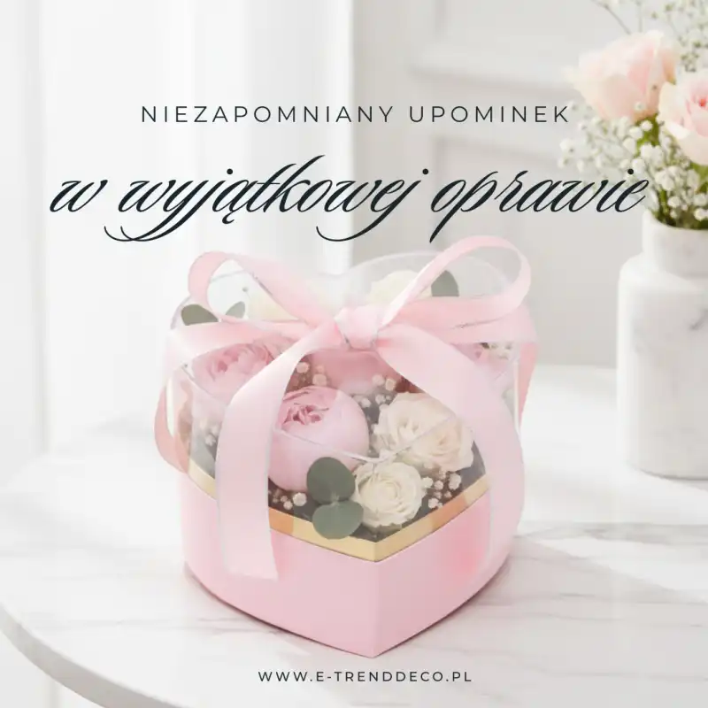 Grafika reklamowa przedstawiająca różowy flower box serce na białym stole z napisami promocyjnymi.