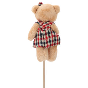 Tylna perspektywa figurki misia na piku, ukazująca sposób wykończenia sukienki z szelkami oraz stabilne mocowanie na patyczku.
