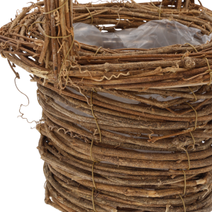 Szczegółowy widok splotu brązowego kosza do kompozycji. Widoczna folia ochronna oraz konstrukcja mocowania rączki.