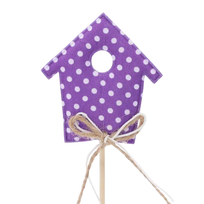 Zbliżenie na fioletowy domek na piku o wysokości 28 cm. Dekoracja posiada wzór w białe kropki oraz jutowy sznurek. Idealny element do wiosennych i wielkanocnych stroików.