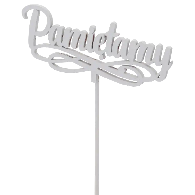 Kadr pod lekkim kątem na drewniany napis Pamiętamy, uwydatniający jego szary kolor oraz ozdobny krój czcionki na drewnianym patyczku.