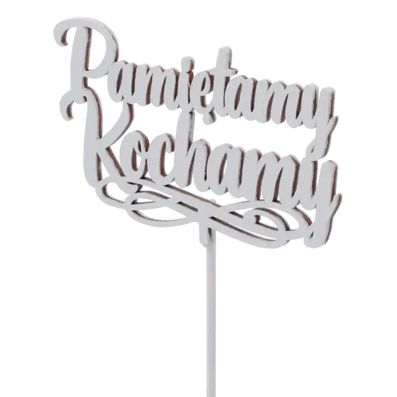 Zbliżenie na szary topper drewniany z napisem Pamiętamy Kochamy. Widoczna faktura drewna i wykończenie dekoracji w kolorze szarym, przeznaczonej do stroików.