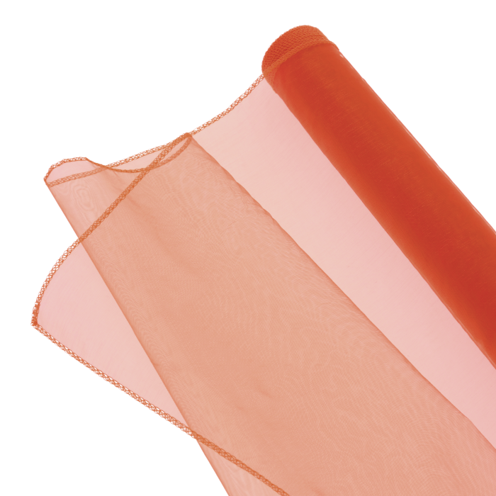 Odcinek pomarańczowej organzy rozwinięty z rolki, prezentujący transparentność i elastyczność materiału dekoracyjnego.