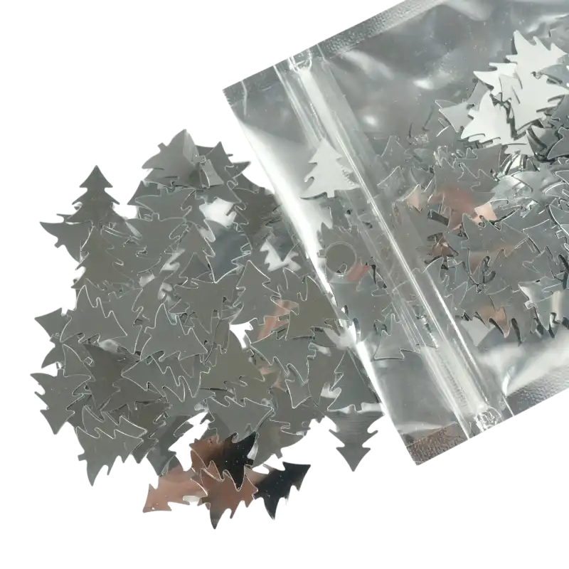 Srebrne confetti w kształcie choinek o rozmiarze ok 2 cm. Opakowanie zawiera 36 g błyszczących ozdób świątecznych.
