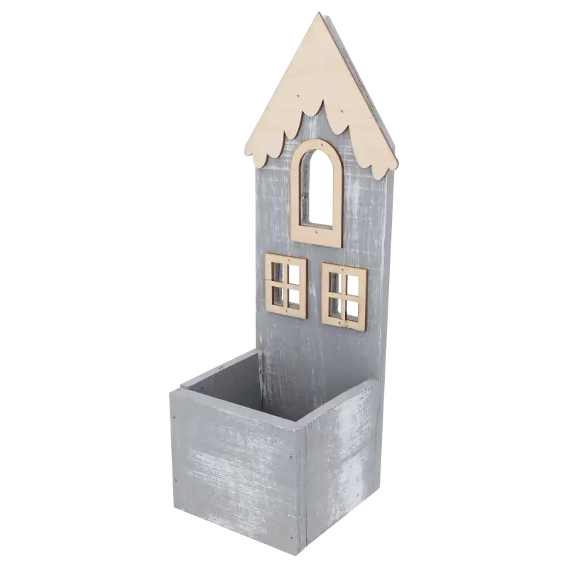 Statuetka domku stojąca na parapecie przy oknie w nocy, podświetlona ciepłym światłem lampek wewnątrz skrzynki.