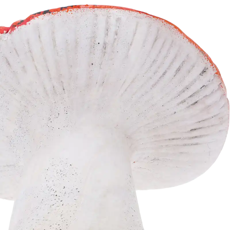 Zbliżenie na czerwony kapelusz muchomora ceramicznego. Wyraźnie widoczna faktura powierzchni i detale wykonania rzeźbiarskiego tej jesiennej dekoracji.