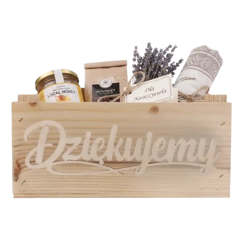 Drewniana skrzynka wypełniona prezentami, w tym miodem, kawą i lawendą, przygotowana jako upominek.