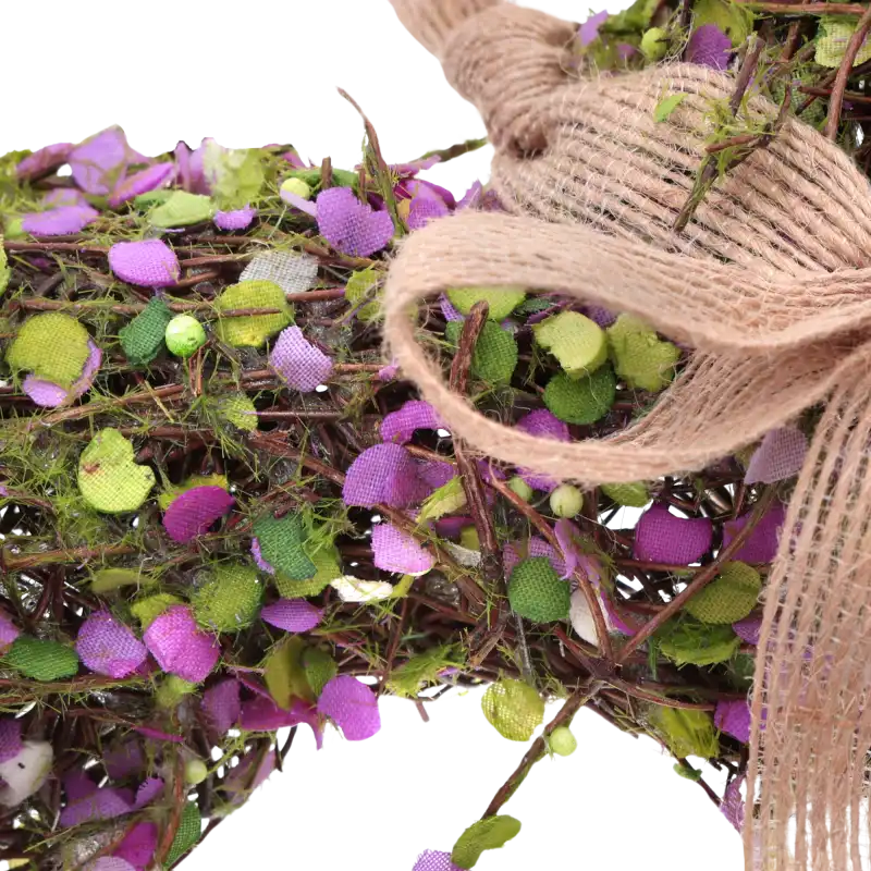 Zbliżenie na splot naturalnej faszyny oraz detal lnianej kokardy w dekoracyjnym sercu wiszącym.