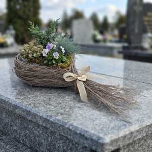 Kompozycja florystyczna z bluszczem w drewnianej osłonce z patyków. Romantyczny kształt serca świetnie prezentuje się na drewnianym stole w salonie.