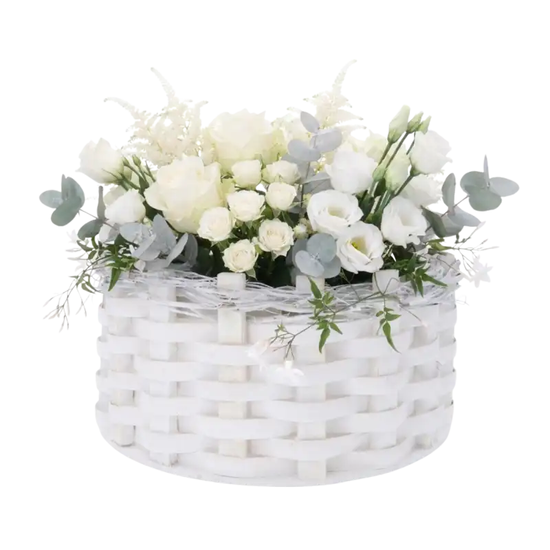 Biała okrągła osłonka rattanowa 32 cm wypełniona bukietem białych róż oraz eukaliptusem, tworząca elegancką dekorację kwiatową.