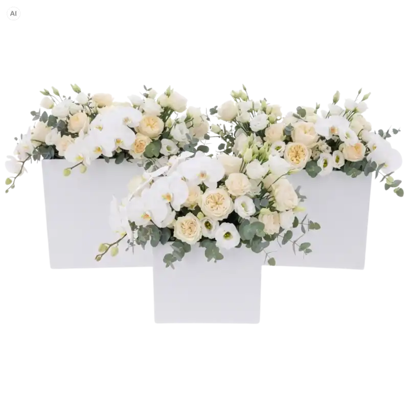 Trzy białe kwadratowe flowerboxy wypełnione jasnymi kwiatami i storczykami, ustawione obok siebie w dekoracyjnej aranżacji.