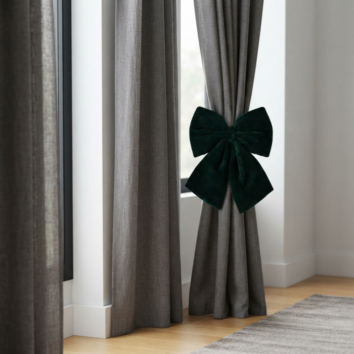 Ciemnozielona welurowa kokarda dekoracyjna 40 cm spina szare zasłony w eleganckim salonie.