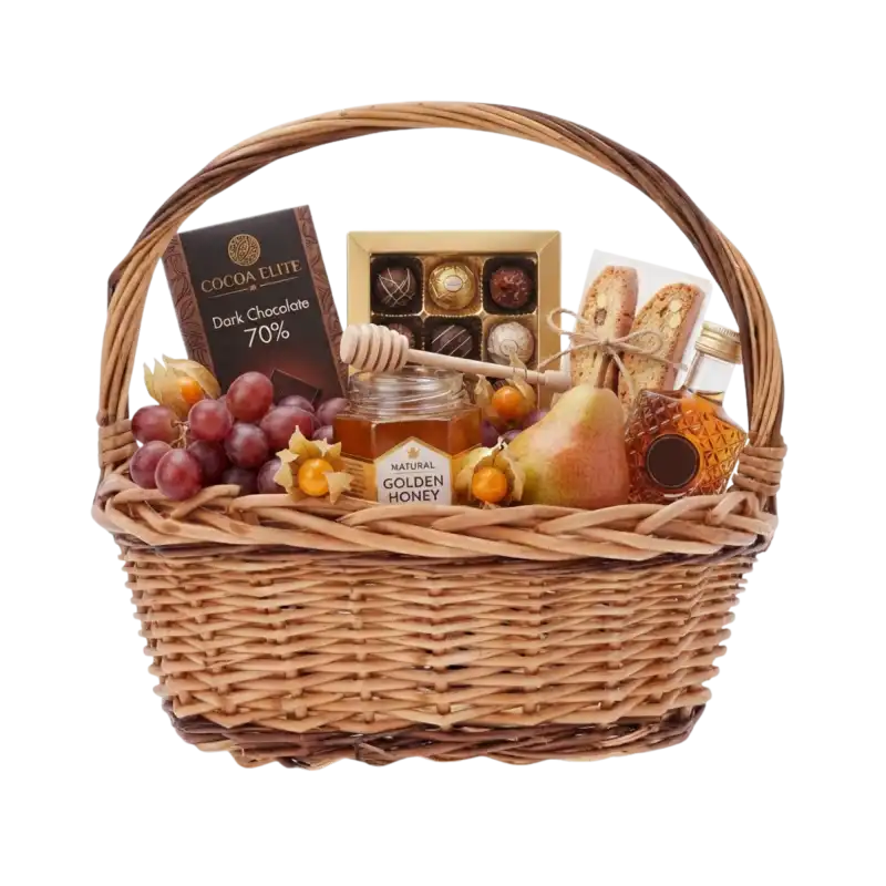 Brązowy owalny kosz wiklinowy 32x28 cm wypełniony słodyczami, miodem, owocami i butelką jako elegancki kosz prezentowy.
