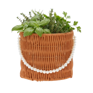 Okrągły brązowy koszyk 16x16x15 cm z plecionki ozdobiony sznurkiem perełek, wypełniony świeżymi ziołami jako domowy zielnik.