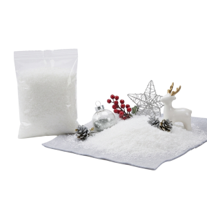 Sztuczny śnieg dekoracyjny w folii 20x15 cm w woreczku obok zimowej aranżacji ze szyszkami, bombką i figurką renifera.