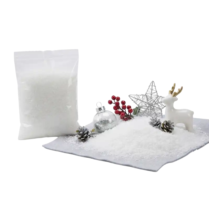 Sztuczny śnieg dekoracyjny w folii 20x15 cm w woreczku obok zimowej aranżacji ze szyszkami, bombką i figurką renifera.